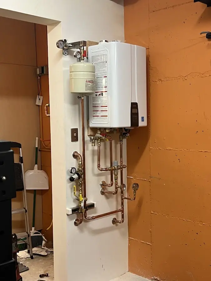 Plumbing technician inspecting water heater connections in Jenks